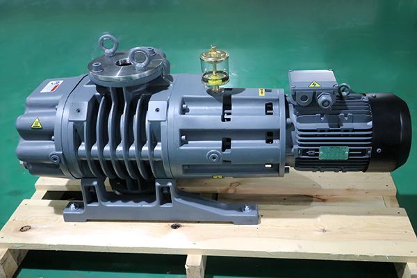 Gray pump and motor mounted on a wooden pallet on a green floor.